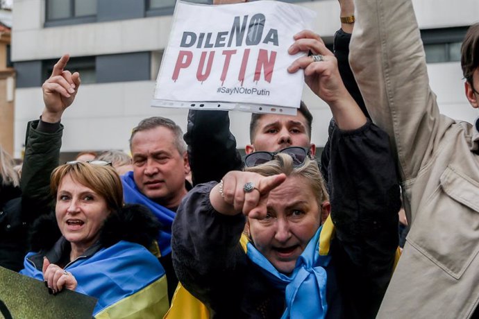 Un grupo de personas sostiene participas en una concentración ante la embajada rusa en Madrid tras los primeros ataques rusos registrados en Ucrania esta pasada madrugada, a 24 de febrero de 2022, en Madrid (España). Ucranianos residentes en Madrid y fa