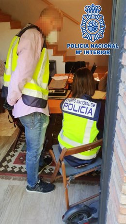 Imagen de dos agentes durante la entrada y el registro en el domicilio del investigado