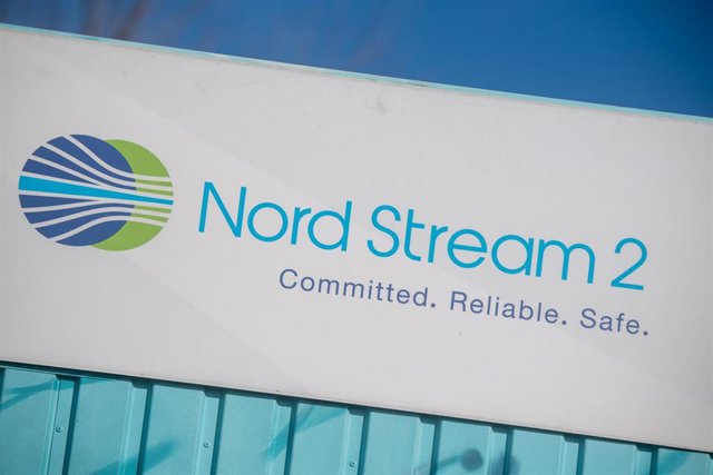 22 February 2022, Mecklenburg-Western Pomerania, Lubmin: A sign reading "Nord Stream 2 Committed. Reliable. Safe." hangs above a painted map on an information container for the Nord Stream 2 gas pipeline at the Lubmin industrial park. The German governmen