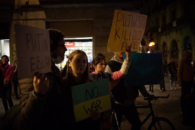 Varias personas sostienen pancartas en una concentración ante la embajada rusa en Barcelona tras los primeros ataques rusos registrados en Ucrania esta pasada madrugada, a 24 de febrero de 2022, en Barcelona, Cataluña (España). 