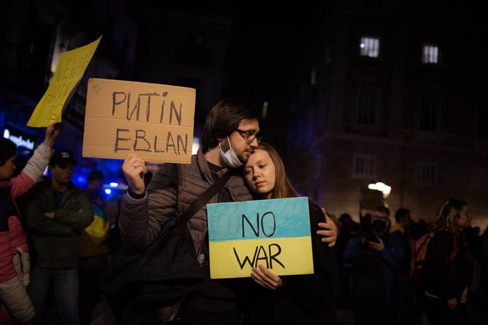 Varias personas sostienen pancartas en una concentración ante la embajada rusa en Barcelona tras los primeros ataques rusos registrados en Ucrania esta pasada madrugada, a 24 de febrero de 2022, en Barcelona, Cataluña (España). Ucranianos residentes en 