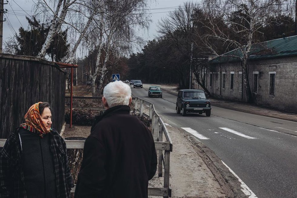 Unos civiles a las puertas de su casa observan la huida de cientos de vecinos, a 24 de febrero de 2022, en Oblast de Lugansk (Ucrania).