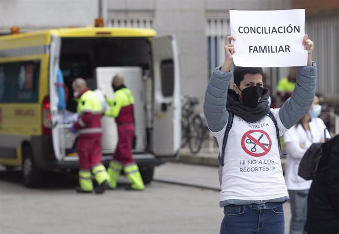 Archivo - Una mujer sostiene una pancarta donde se lee "conciliación familiar" durante una concentración de trabajadores sanitarios en defensa de la sanidad pública, a las puertas del Hospital Clínico San Carlos, en Madrid (España), a 11 de febrero de 2