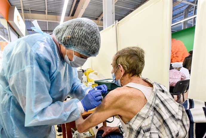 Archivo - 19 October 2021, Ukraine, Zaporizhzhia: A medical worker administers a dose of a Corona vaccine to a man at a vaccination center in a shopping mall.