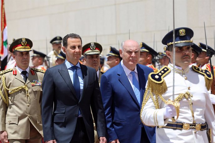 Archivo - HANDOUT - 17 May 2021, Syria, Damascus: A handout picture provided by the Syrian Arab News Agency (SANA) on 17 May 2021 shows Syrian President Bashar al-Assad (2nd L) and Aslan Bzhania (2nd R), President of Abkhazia, inspecting the guard of ho