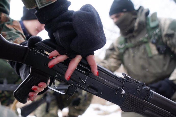 A female trainee soldier, wearing red nail polish, from the civilian volunteer of the Obukhiv Civilian Protection force learns how to handle an automatic weapon. Men and women in Ukraine feel an obligation to learn the skills required to be able to defe