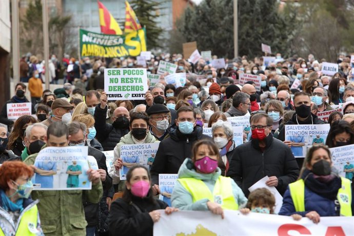Varias personas con pancartas que dicen 'Ser pocos no resta derechos, Teruel existe' y 'Salvemos la Atención Primaria' durante una manifestación en defensa de la Atención Primaria para la población de las zonas rurales, a 16 de febrero de 2022, en Terue