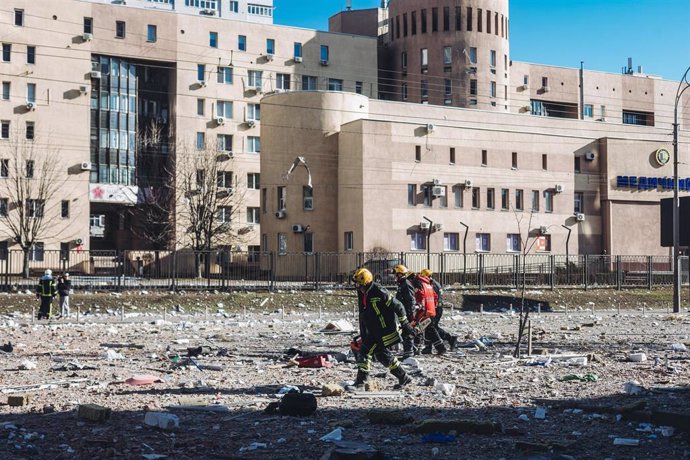 Bomberos y servicios de emergencia en las inmediaciones del edificio civil bombardeado, en una zona residencial, a 26 de febrero de 2022, en Kiev (Ucrania). 