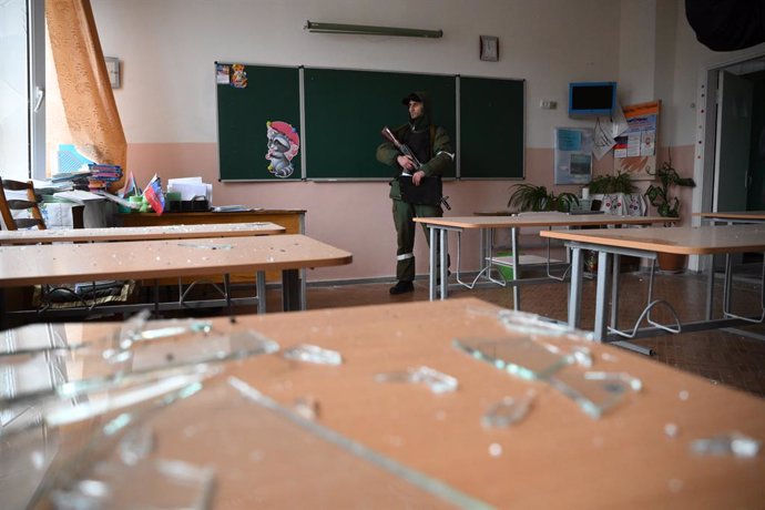 An employee of the DPR People's Militia stands in a classroom of the school, damaged as a result of shelling, on February 25, 2022, in Horlivka, Donetsk, Ukraine. On February 24 Russian President Vladimir Putin announced a military operation in Ukraine 