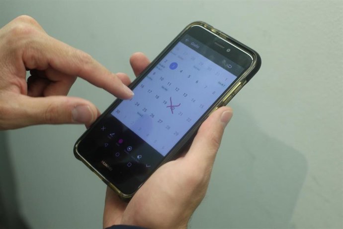 Archivo - Una persona marca varios días en el calendario de su teléfono móvil.