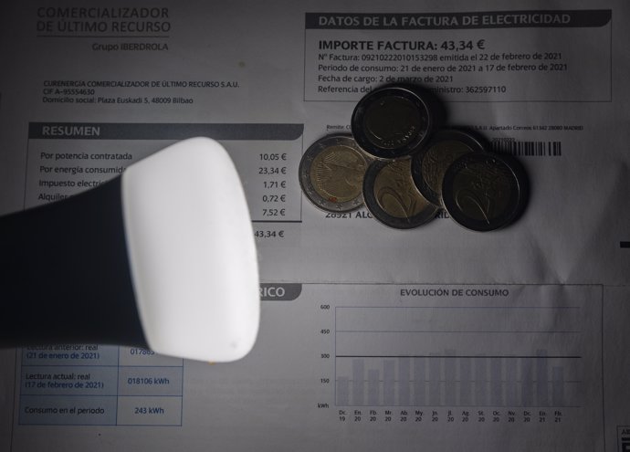 Una lámpara refleja el importe de una factura el día en que el precio de la luz ha marcado un mínimo por primera vez en dos meses, a 27 de diciembre de 2021, en Madrid, (España).