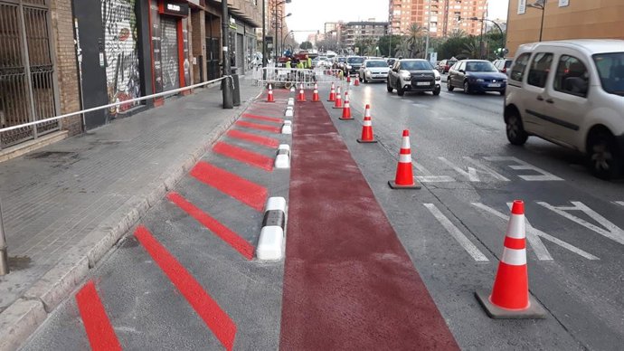 Trabajos de pintura de la calzada e instalación de los bordillos que limitan los nuevos espacios ganados para los viandantes en la avenida Pérez Galdós de Valncia.