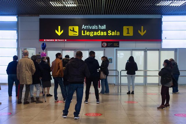 Varias personas esperan en una de las puertas de llegadas, en la Terminal 1 del Aeropuerto Adolfo Suárez Madrid Barajas el día en que Rusia ha anunciado restricciones en su espacio aéreo a compañías británicas o registradas en Reino Unido
