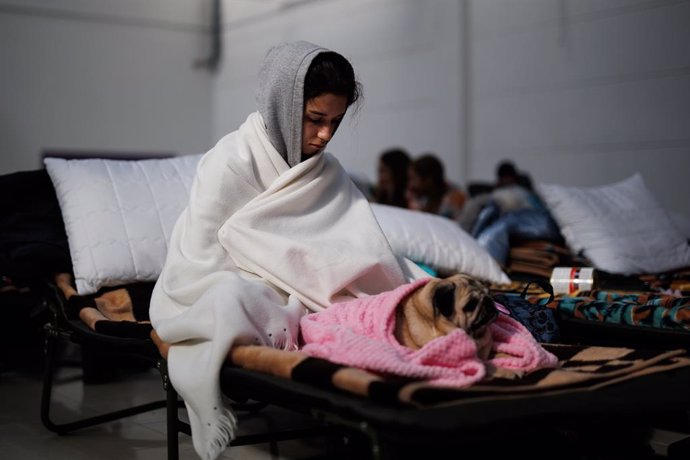 Una chica, con su perro, en un centro comercial habilitado para los refugiados, en Mylny, a 27 de febrero de 2022, en Jaroslaw, Subcarpacia, (Polonia). Ucrania ha confirmado, por el momento, la muerte de más de 3.000 personas y según datos de ACNUR este