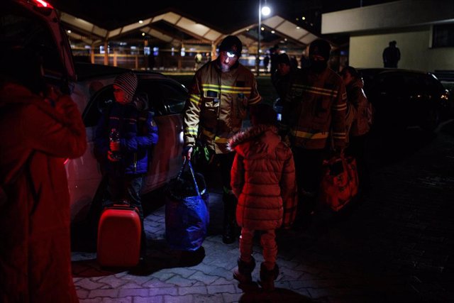 Voluntarios ayudan a refugiados ucranianos al llegar a la estación de tren de Przemysl (Polonia)