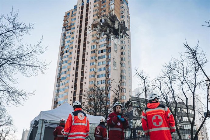 Servicios de emergencia frente al edificio civil bombardeado en una zona residencial en Kiev (Ucrania)