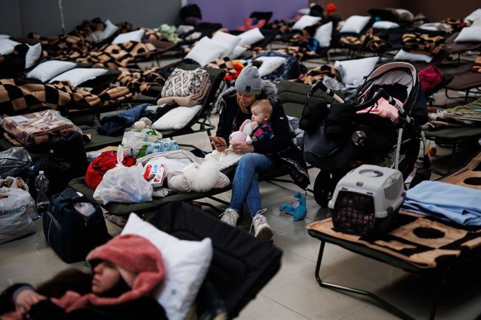 Una mujer con un bebé, en un centro comercial habilitado para los refugiados, en Mylny, a 27 de febrero de 2022, en Jaroslaw, Subcarpacia, (Polonia). Ucrania ha confirmado, por el momento, la muerte de más de 3.000 personas y según datos de ACNUR este d