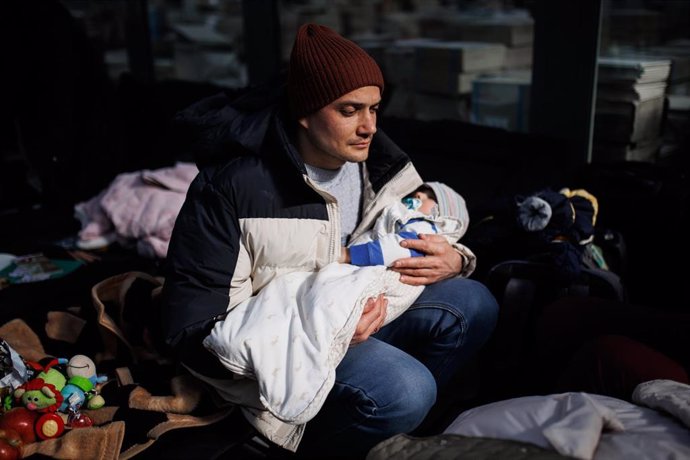 Una hombre sostiene un bebé, en un centro comercial habilitado para los refugiados, en Mylny, a 27 de febrero de 2022, en Jaroslaw, Subcarpacia, (Polonia). Ucrania ha confirmado, por el momento, la muerte de más de 3.000 personas y según datos de ACNUR 