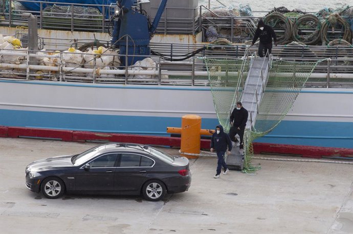 (I-D) El patrón, Juan Padín; su sobrino, Eduardo Rial Padín; y Samuel Kwesi, tripulantes del pesquero gallego que naufragó en aguas canadienses, bajan del pesquero español 'Playa Menduiña Dos' a su llegada al Puerto de San Juan de Terranova, a 19 de feb