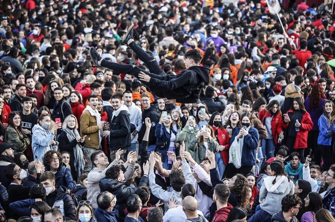 Un grupo de personas levanta a un joven en la Crida de las Falleras Mayores para dar comienzo a las Fallas en las Torres de Serrano