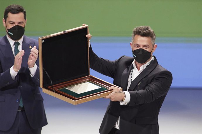 El presidente de la Junta, Juanma Moreno, (i) entrega el título de Hijo Predilecto de Andalucía al cantante, Alejandro Sanz, (d) durante el acto de entrega de Medallas de Andalucía 2022 en el Teatro de la Maestranza, a 28 de febrero de 2022 en Sevilla (