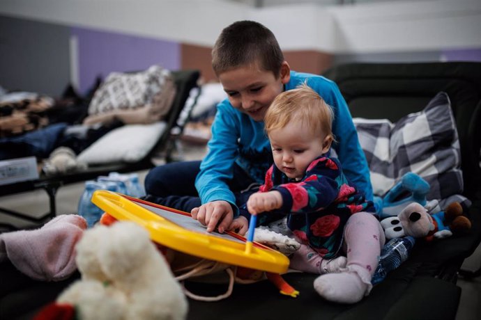 Dos niños juegan en un centro comercial habilitado para los refugiados, en Mylny, a 27 de febrero de 2022, en Jaroslaw, Subcarpacia, (Polonia). Ucrania ha confirmado, por el momento, la muerte de más de 3.000 personas y según datos de ACNUR este domingo