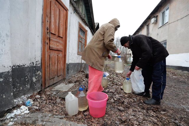 27, 2022 -- Residentes locales llevan botellas de agua en Donetsk, el 26 de febrero de 2022.,Imagen: 665157061, Licencia: Derechos gestionados, Restricciones: , Liberación del modelo: no, Línea de crédito: V Ictor / Xinhua News / ContactoPhoto  Licencia e
