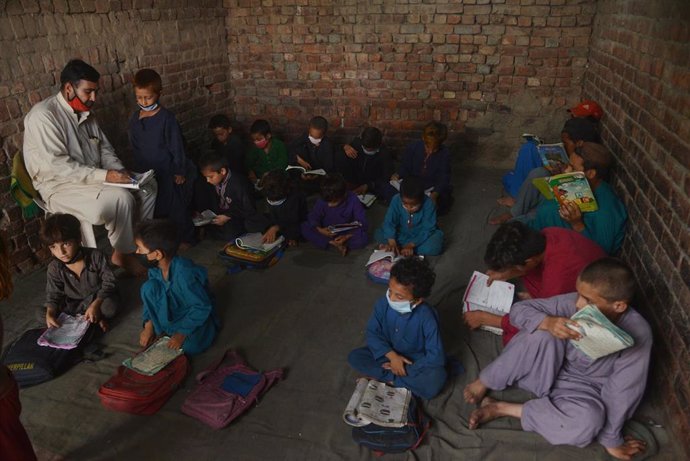 Archivo - Niños afganos en una escuela improvisada en un campamento de refugiados en la ciudad paquistaní de Lahore
