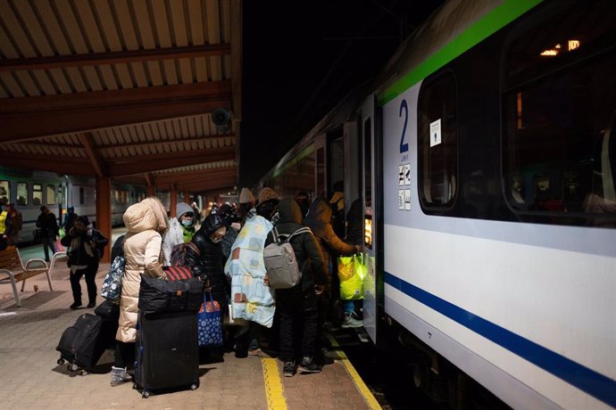 Grupos de personas con sus enseres entran un tren de la estación de Przemysl, cinco días después del inicio de los ataques por parte de Rusia en Ucrania, a 1 de marzo de 2022, en Przemysl (Polonia).