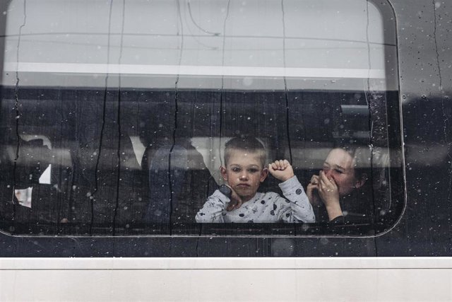 Un niño y su madre observan desde un tren en la estación de tren de Kiev, en Ucrania