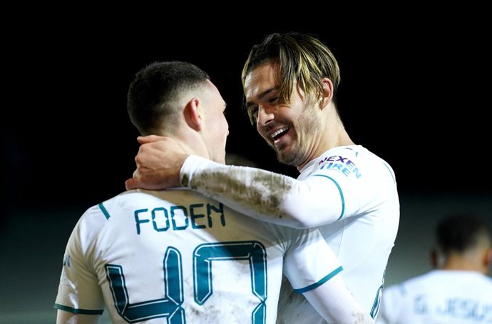 01 March 2022, United Kingdom, Peterborough: Manchester City's Jack Grealish (R) celebrates scoring his side's second goal with team-mate Phil Foden during the English FA Cup fifth round soccer match between Peterborough United and Manchester City at th