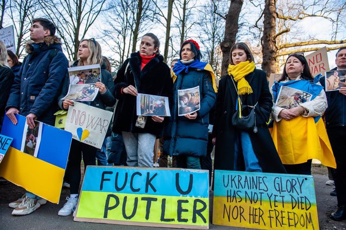 febrero de 2022, La Haya, Sur de Holanda, Países Bajos: (NOTA DEL EDITOR : La imagen muestra palabrotas).Manifestantes ucranianos sostienen pancartas mientras escuchan el debate en la cámara de representantes..La comunidad ucraniana en Holanda se reúne 