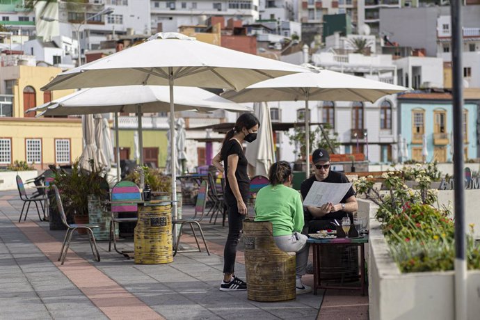 Archivo - Una camarera atiende a dos personas en un establecimiento del municipio de Tazacorte, que ya no permanece confinado, a 23 de noviembre de 2021, en Tazacorte, Santa Cruz de Tenerife, Canarias, (España). Esta medida, que afectó a más de 3.000 pe