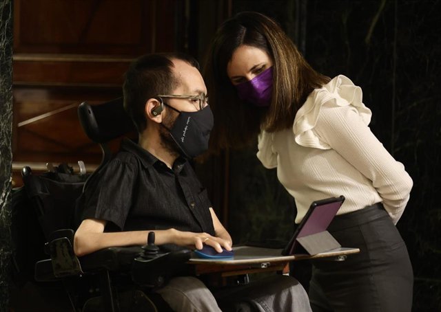 El portavoz de Unidas Podemos en el Congreso, Pablo Echenique, conversa con la ministra de Derechos Sociales y Agenda 2030, Ione Belarra, a su llegada a una sesión plenaria, en el Congreso de los Diputados, a 2 de marzo de 2022, en Madrid (España).