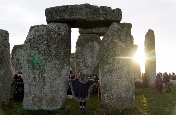 Archivo - 22 December 2021, United Kingdom, Amesbury: A woman stands next to stones as they take part in the winter solstice celebrations during sunrise at the Stonehenge prehistoric monument on Salisbury Plain in Wiltshire. Photo: Andrew Matthews/PA Wi