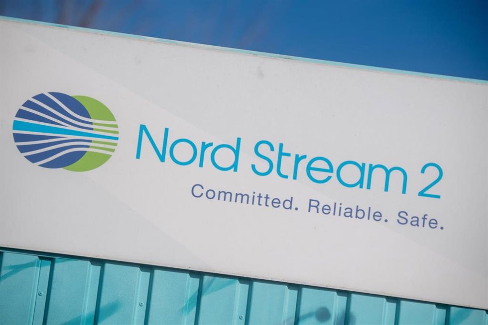 22 February 2022, Mecklenburg-Western Pomerania, Lubmin: A sign reading "Nord Stream 2 Committed. Reliable. Safe." is seen on an information container for the Nord Stream 2 gas pipeline at the Lubmin industrial park.  The Kremlin is sticking to the cont