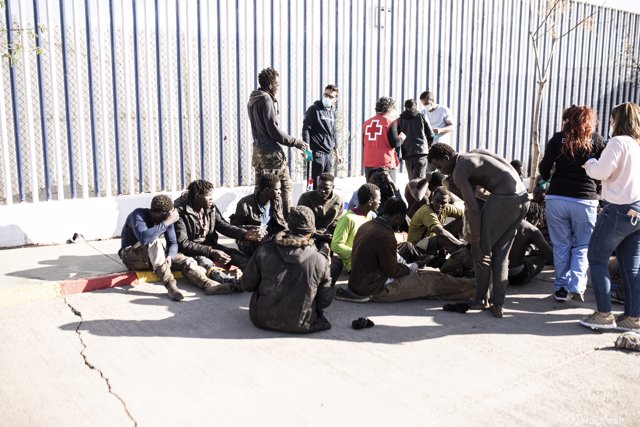 Varios migrantes son atendidos por personal de la Cruz Roja, tras saltar la valla de Melilla 