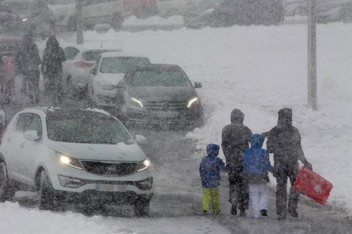 Archivo - Una familia camina por una vía nevada, a 8 de diciembre de 2021, en Lugo, Galicia, (España). La borrasca Barra ha provocado la activación para todo el litoral gallego de una alerta naranja por temporal costero y de alerta amarilla por nevadas 