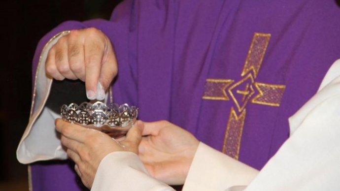 Un sacerdote se dispone a imponer la ceniza a los fieles.