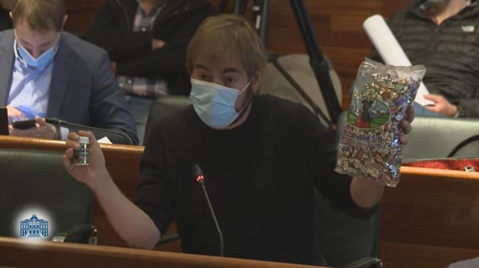 El diputado de Podemos, Daniel Ripa, en la Junta General con un paquete de caramelos La Asturiana.