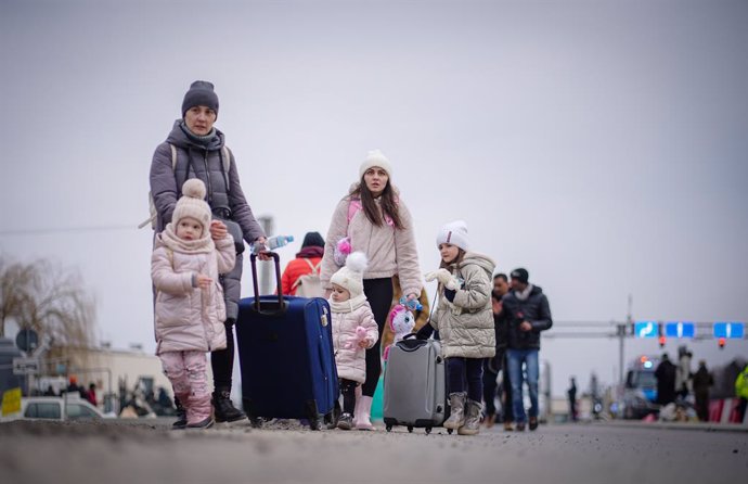 02 March 2022, Poland, Medyka: Two sisters cross the Ukrainian-Polish border with their children. According to UN figures, 677,000 people have fled Ukraine to neighboring countries since the start of the Russian attack. Photo: Kay Nietfeld/dpa
