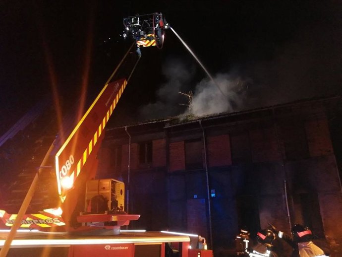 Bomberos trabajan en la extinción de un incendio en un edificio abandonado en Jove