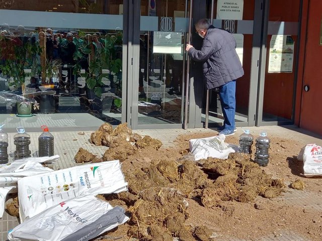 Agricultores de Unió de Pagesos han dejado estiércol y botellas con purín en la puerta de los Servicios Territoriales de la Conselleria de Acción Climática, Alimentación y Agenda Rural de Lleida.