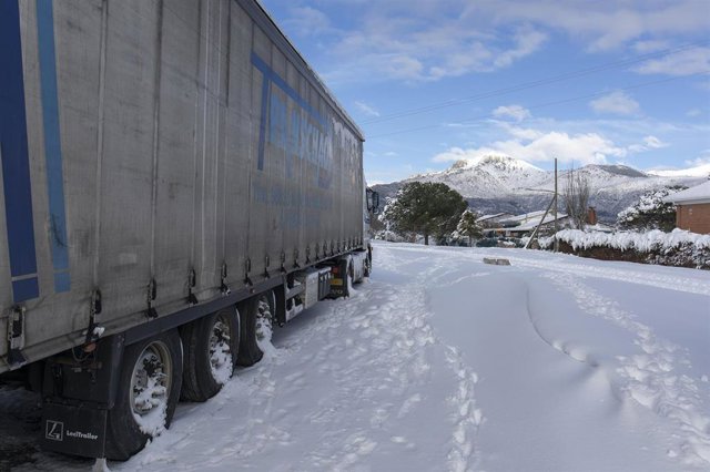 Archivo - Un camión frente a la Sierra de Madrid tras una fuerte nevada.