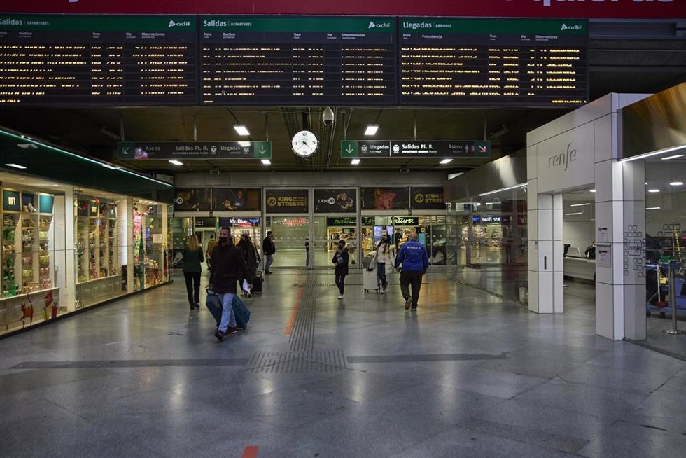Archivo - Varias personas con maletas en la estación de Atocha, viajan con motivo de la Nochebuena 2021, a 24 de diciembre de 2021, en Madrid (España). 