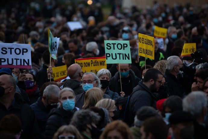 Varias personas sostienen pancartas durante una concentración para reclamar el alto al fuego y la retirada de las tropas rusas de Ucrania