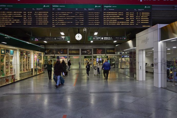 Archivo - Varias personas con maletas en la estación de Atocha, viajan con motivo de la Nochebuena 2021, a 24 de diciembre de 2021, en Madrid (España). Renfe ofrece cerca de 5 millones de plazas en los 23.000 trenes que pondrá en circulación esta Navida