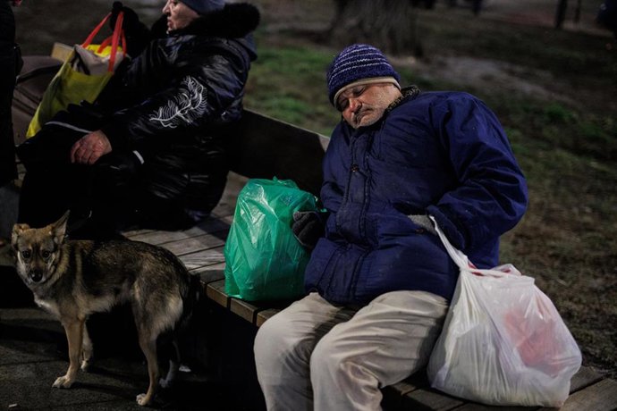 Un hombre dormido en un banco en las inmediaciones de la estación de tren de Lviv, a 2 de marzo de 2022, en Leópolis (Ucrania)