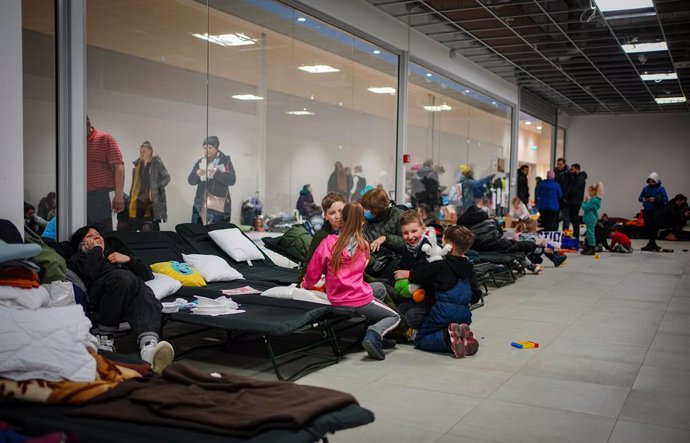 03 March 2022, Poland, Przemysl: Refugees sit in a refugee shelter, a former mall in Przemysl, near the Ukrainian-Polish border. Numerous people arrive here every day, fleeing the war in Ukraine. Photo: Kay Nietfeld/dpa