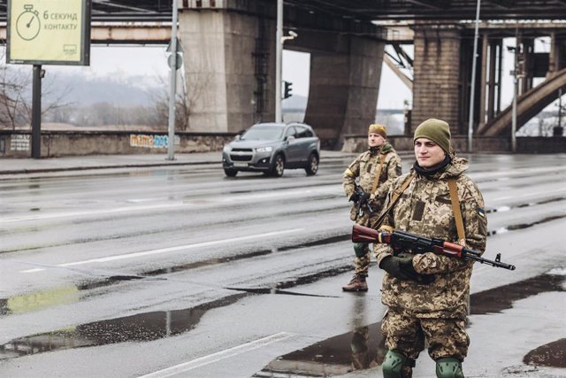 Dos milicianos ucranianos controlan una carretera, a 2 de marzo de 2022, en Kiev (Ucrania). Las autoridades de Kiev han declarado el toque de queda en la ciudad ante la situación causada por la ofensiva rusa en el país. Más de 2.000 civiles ucranianos han